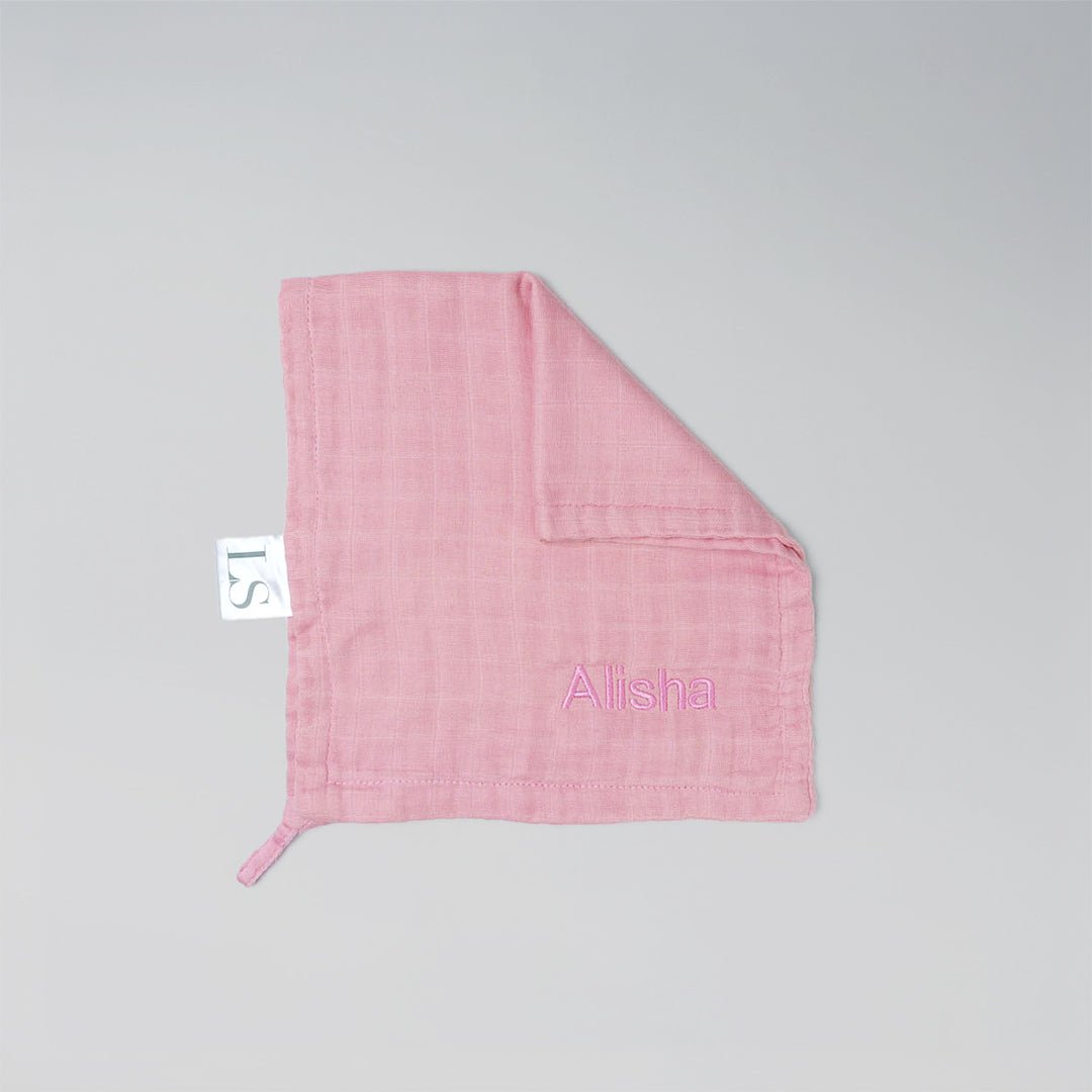 Light PIink muslin washcloth with 'Alisha' embroidered on it.