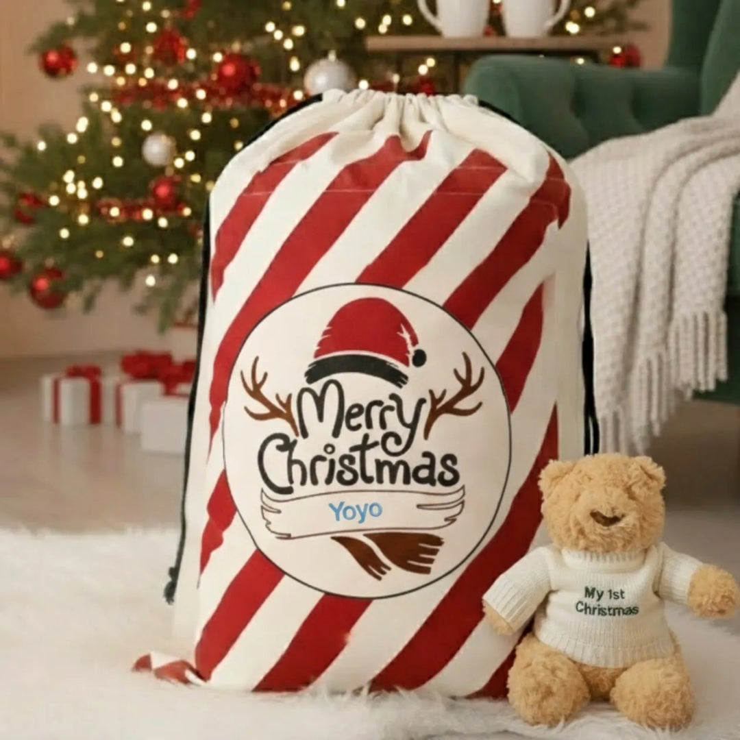 Red and white striped Christmas sack with 'Merry Christmas' design and 'Yoyo' customized on it, next to a teddy bear in a festive setting.