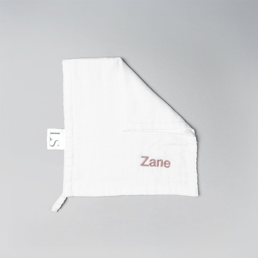 White muslin washcloth with 'Zane' embroidered