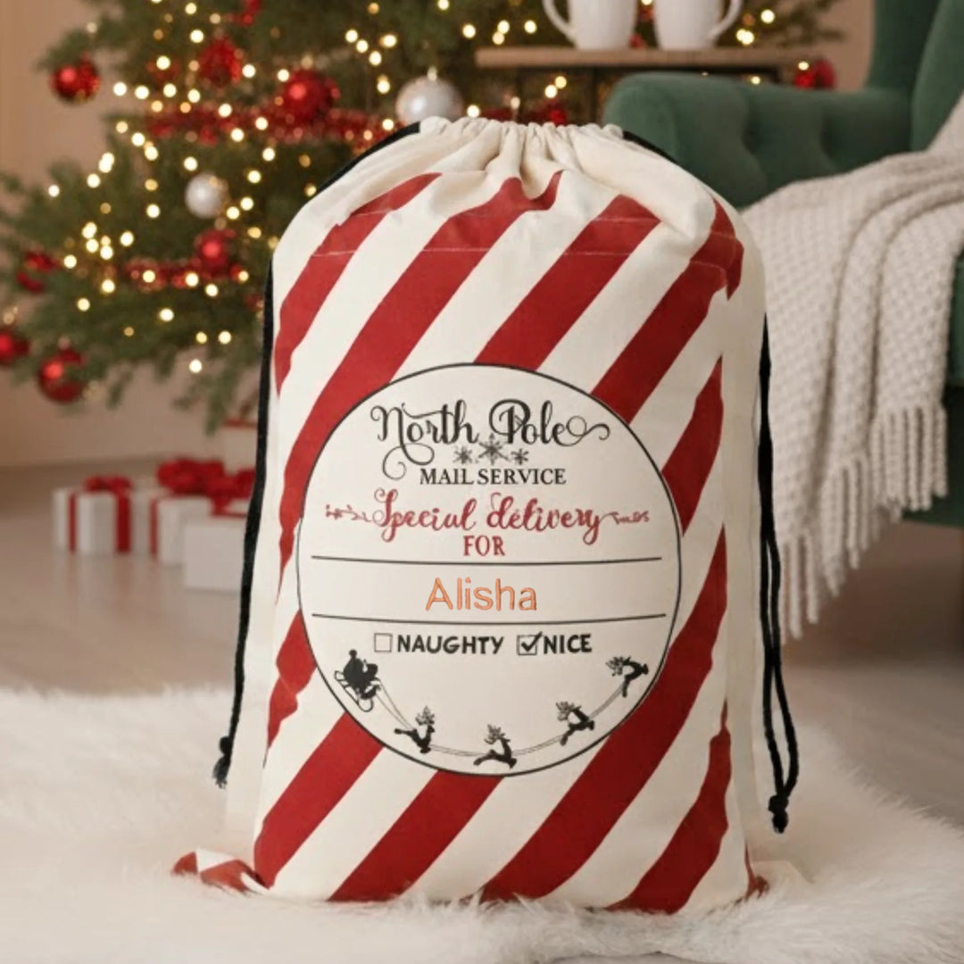 Red and white striped christmas bag with personalized label in a festive room.