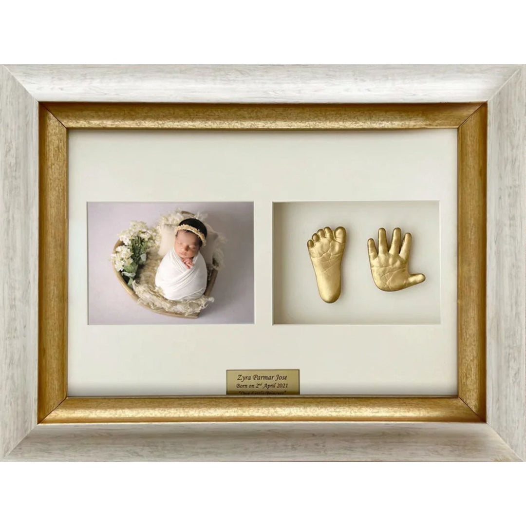 Framed baby photo with gold hand and footprints on a white background