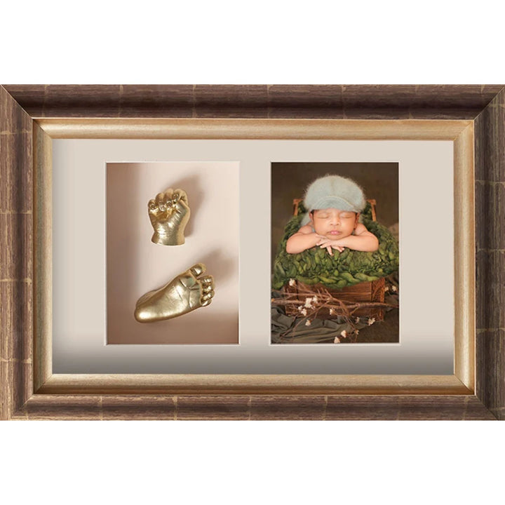 Framed artwork with gold baby footprints and a photo of a baby in a green outfit.