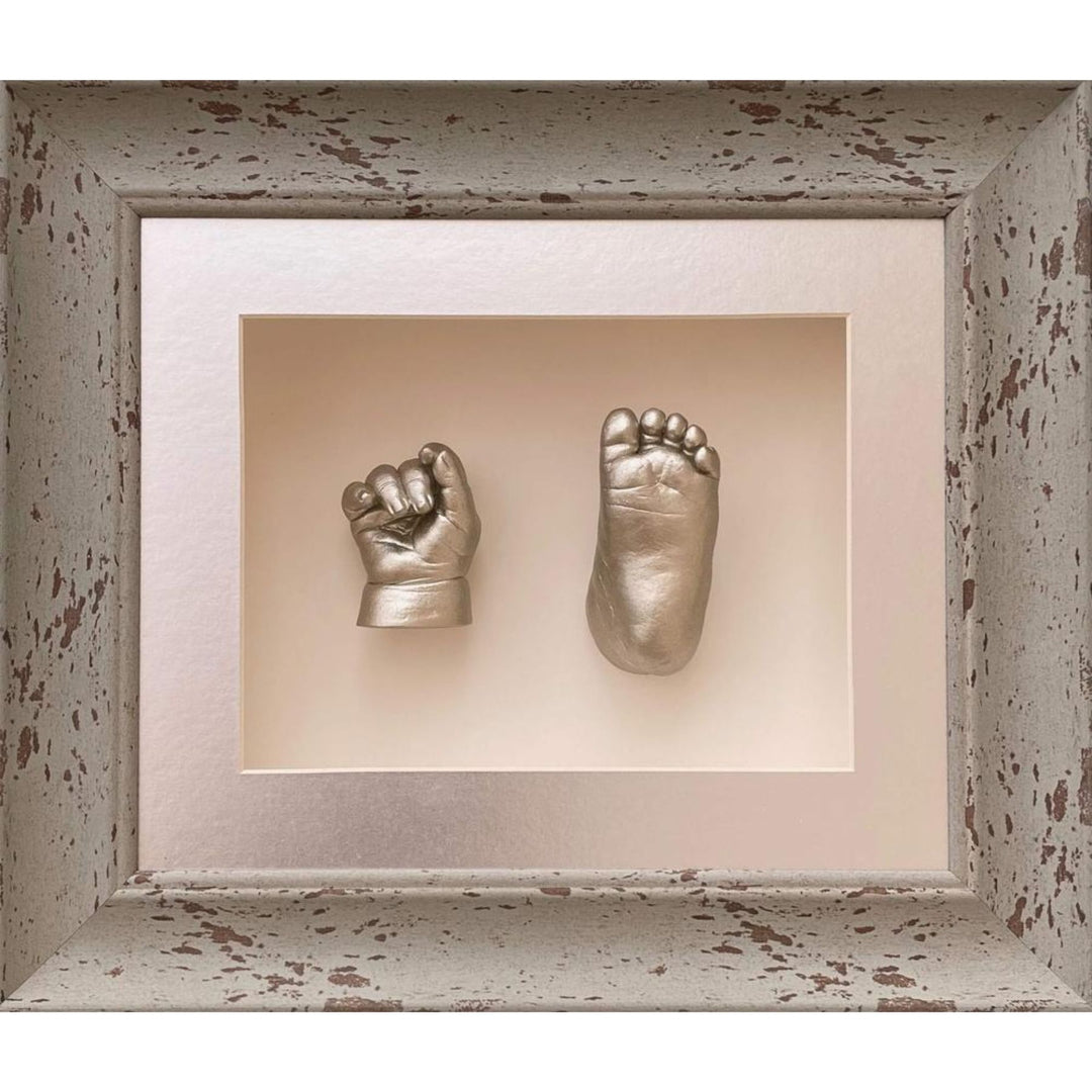 Silver baby hand and footprints in a decorative frame.