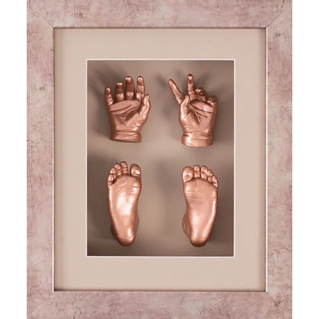 Framed copper hand and foot impressions on a textured wall.