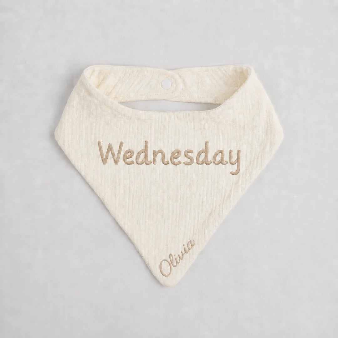 Baby bib with 'Wednesday' and 'Olivia' embroidered on a light gray background