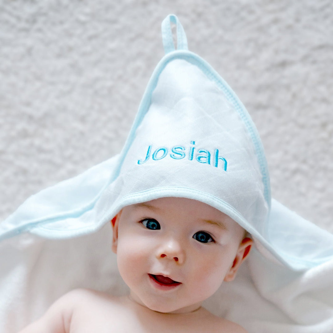 Baby covering in Blue Bamboo Hooded Towel with "Josiah" customised in Blue thread