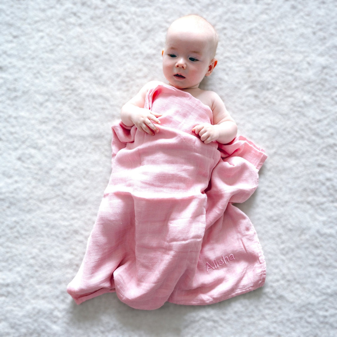 baby wrapped in a pink swaddle