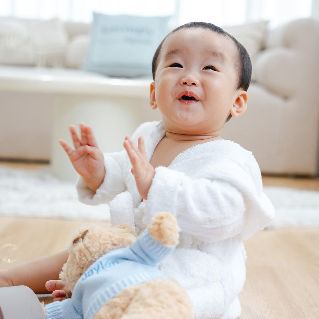 Happy Baby in white bamboo bathrobe and hugsy bear