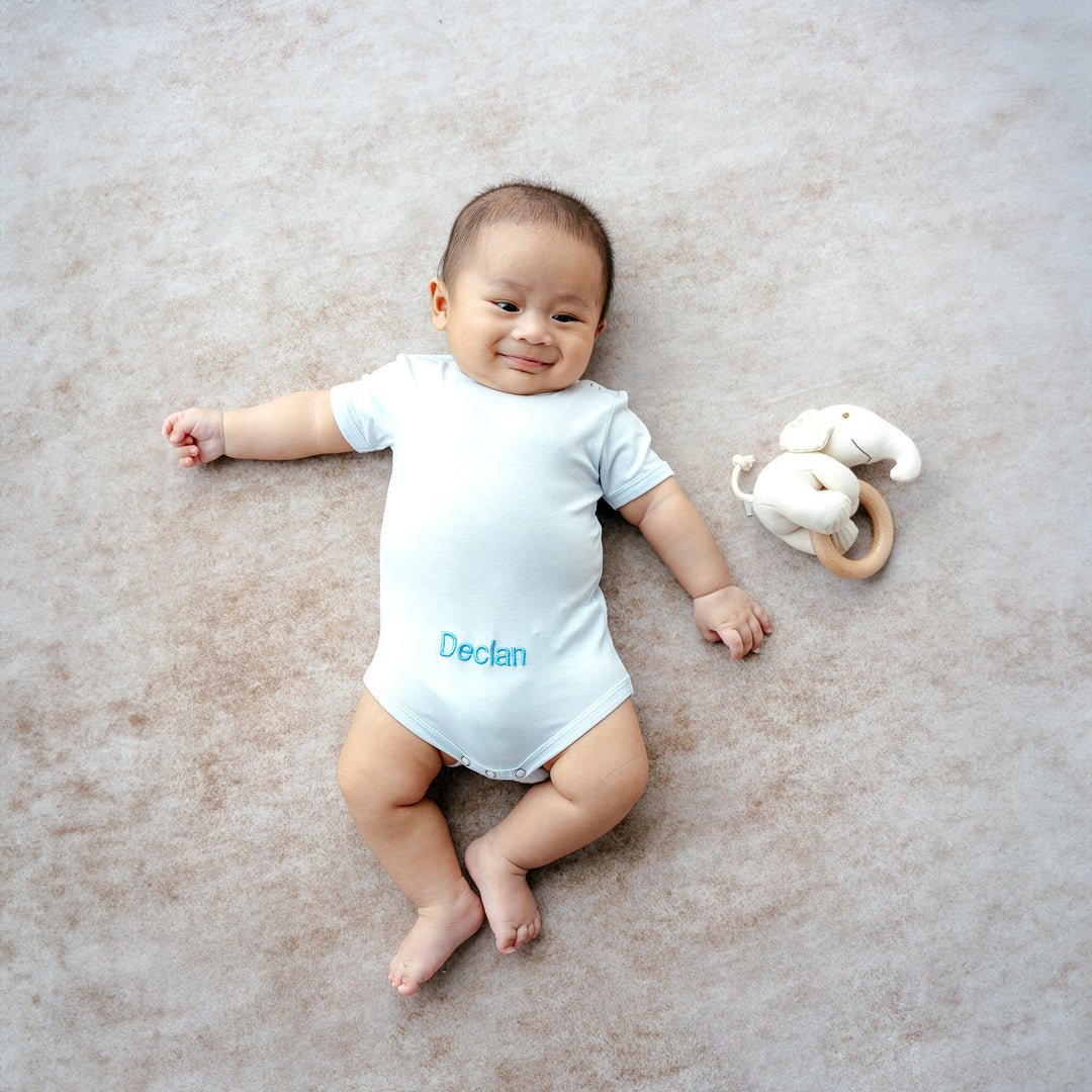 Baby in Blue Short Sleeve Babygrow with "Declan" personalised in Blue Thread