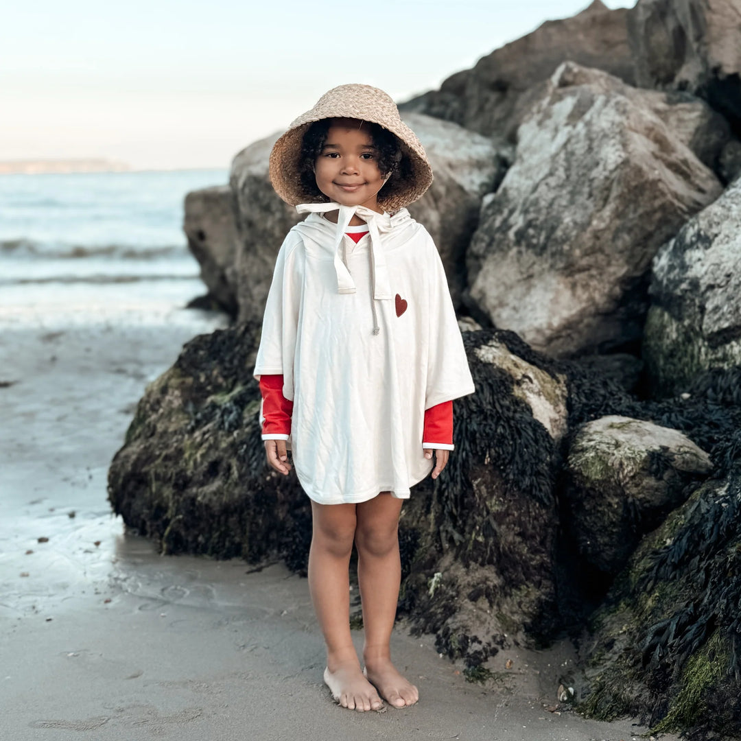 Child wearing Cosy Roots Organic UV Poncho - Sand