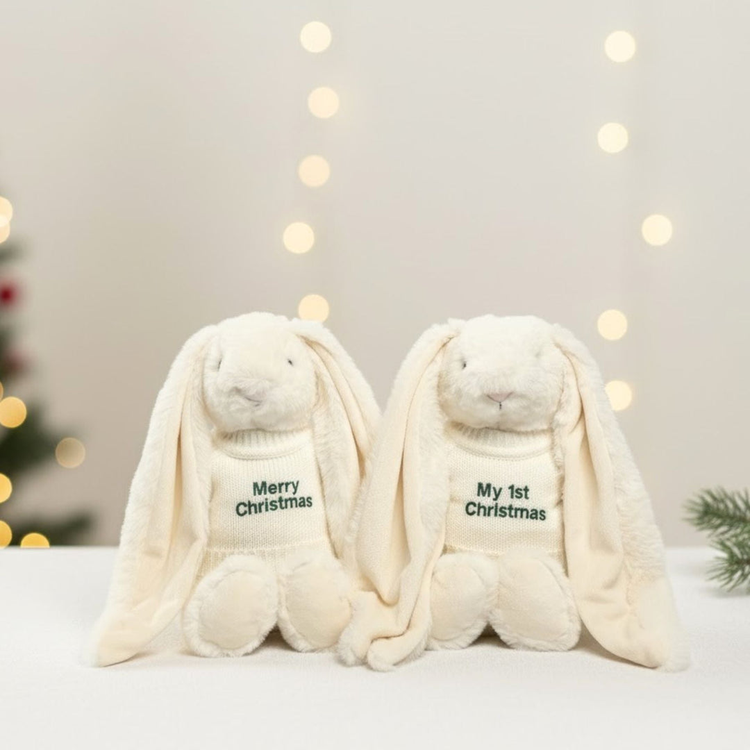 Two plush bunny toys with 'Merry Christmas' and 'My 1st Christmas' text against a festive background.