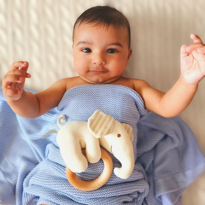 Baby covering in Blue Bamboo Cellular Blanket and playing with Elephant Rattle Toy 