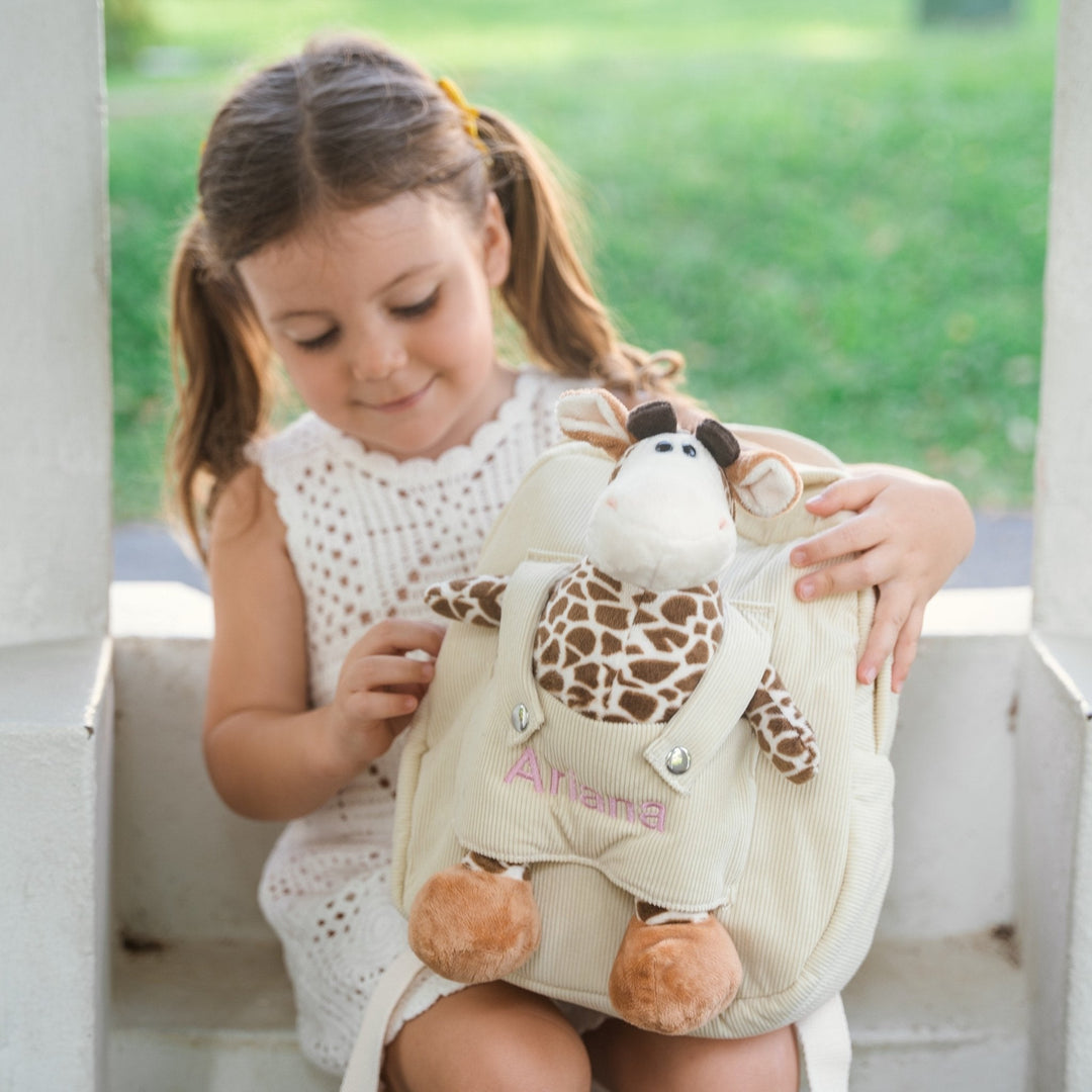 Girl opening giraffe bag with "Ariana" personalised in pink thread