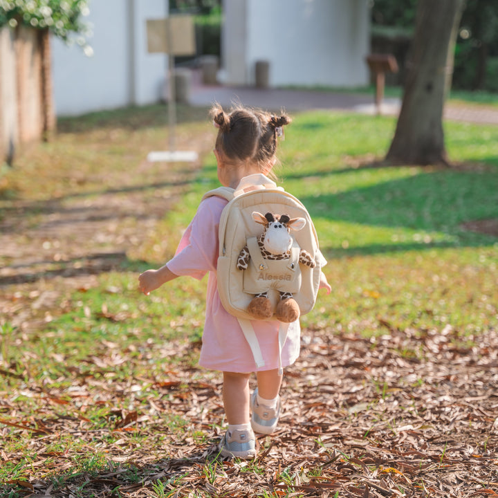 Girl carrying giraffe bag personalised in pink thread