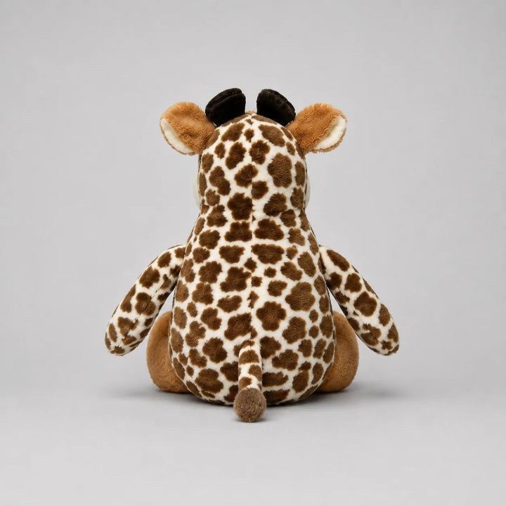 Back view of a brown and cream spotted giraffe soft toy with a small tail, photographed on a light grey studio background.