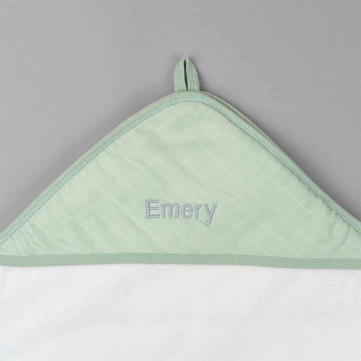 Green hooded towel with "Emery" personalised in grey thread