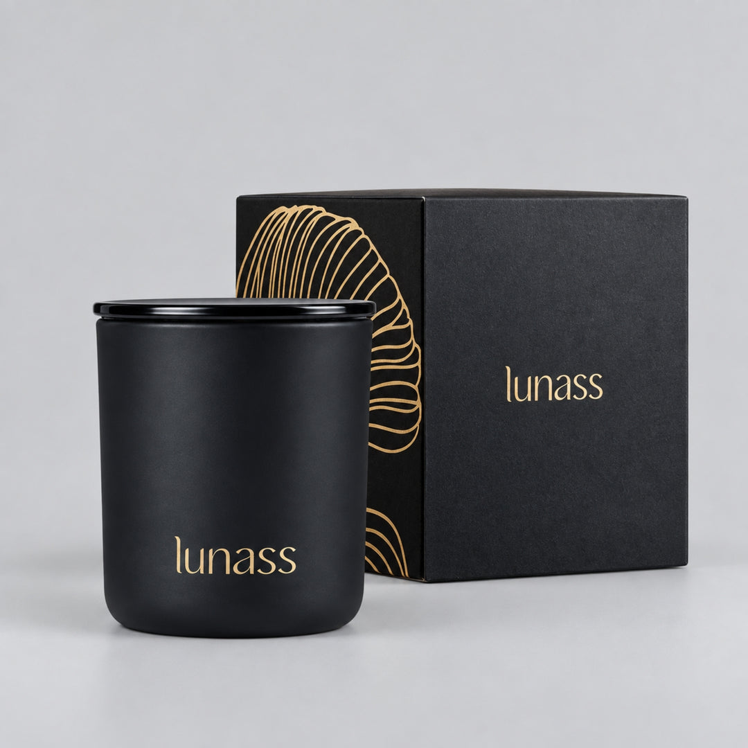 Black LUNASS luxury scented candle with matching black and gold presentation box on a light grey studio background.