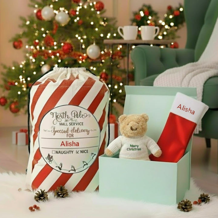 Christmas-themed gift set with teddy bear, stocking, and personalized bag in a festive setting.