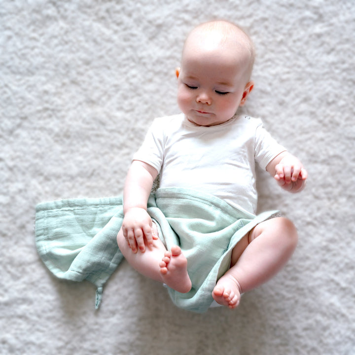 Baby using Green Muslin Wash Cloth