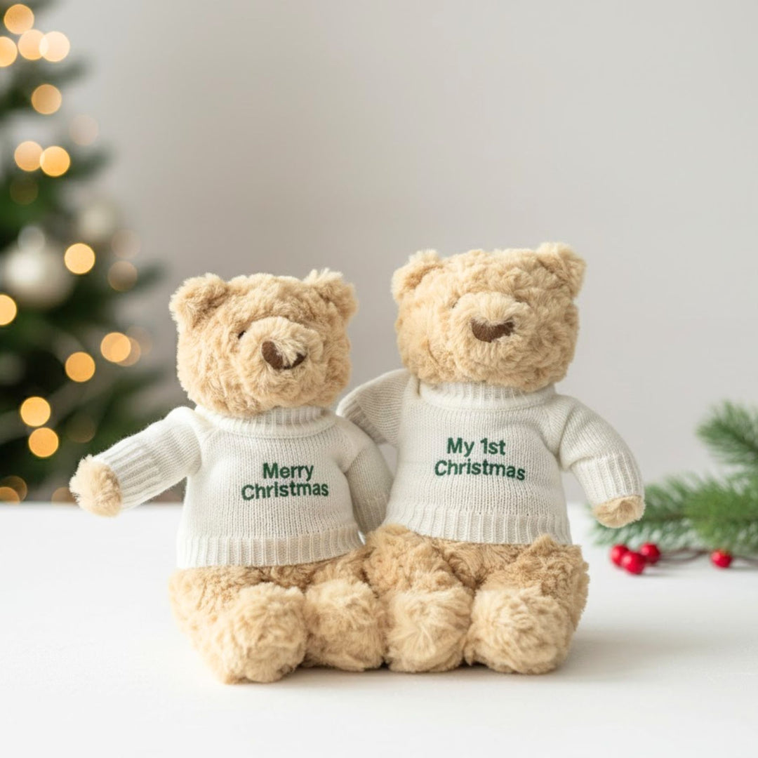 Two teddy bears wearing sweaters with 'Merry Christmas' and 'My 1st Christmas' text, with a festive background.