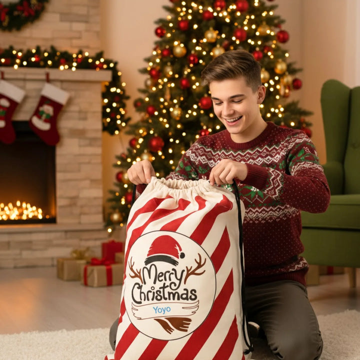 Man in festive sweater with a large personalised Christmas sack in a decorated living room.