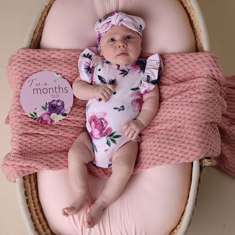 Baby wearing Snuggle Hunny Floral Kiss Short Sleeve Organic Bodysuit with Frill