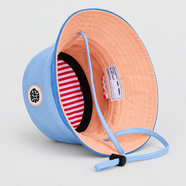 Interior view of the Hello Hossy blue bucket hat showing peach lining, striped inner band, chin strap and product label.