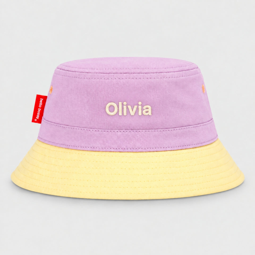Back view of a lilac and cream Hello Hossy bucket hat personalised with “Olivia” in cream block embroidery and red side tag.