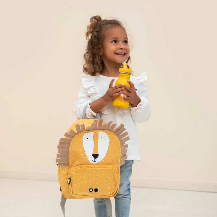 Child holding Trixie Mr Lion backpack and matching yellow water bottle, kids backpack UAE