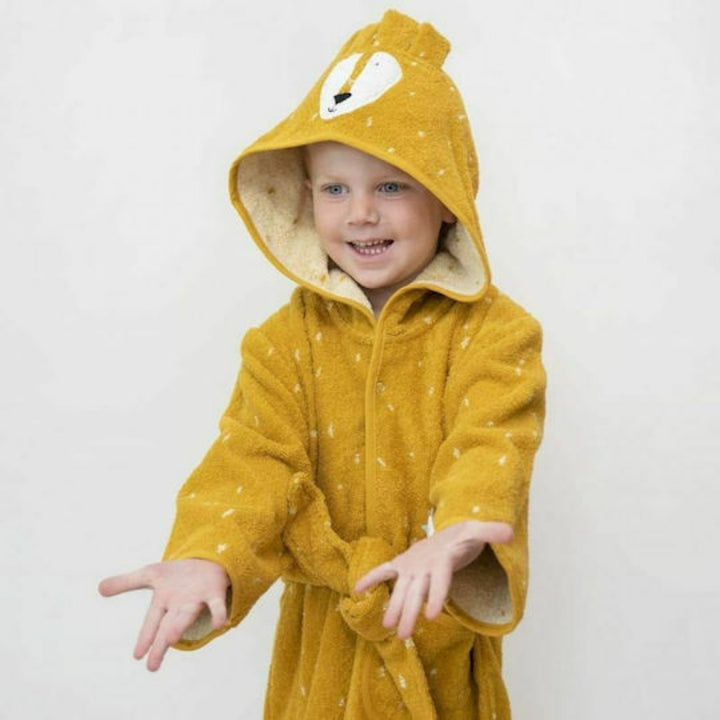 A smiling young child wearing a mustard yellow lion bathrobe with a character hood, white speckled pattern and matching waist belt, photographed against a light neutral background.