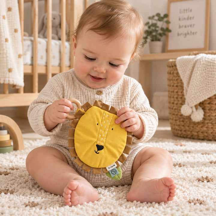Baby playing with Trixie Lion sensory activity book with wooden teething ring, baby toy UAE