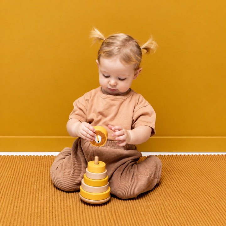 Toddler playing with Trixie Lion wooden stacking toy, educational baby toy UAE