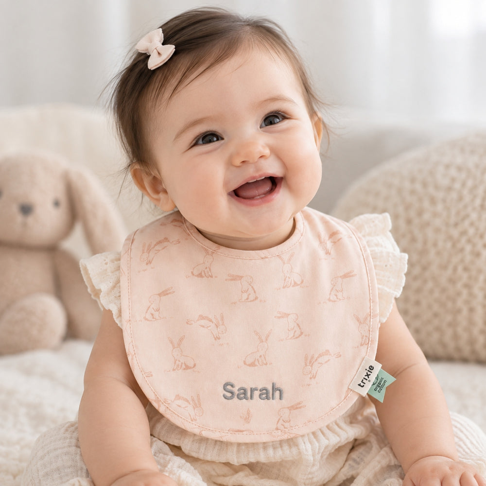 Baby girl wearing personalised pink Trixie bunny bib with Sarah embroidered, UAE