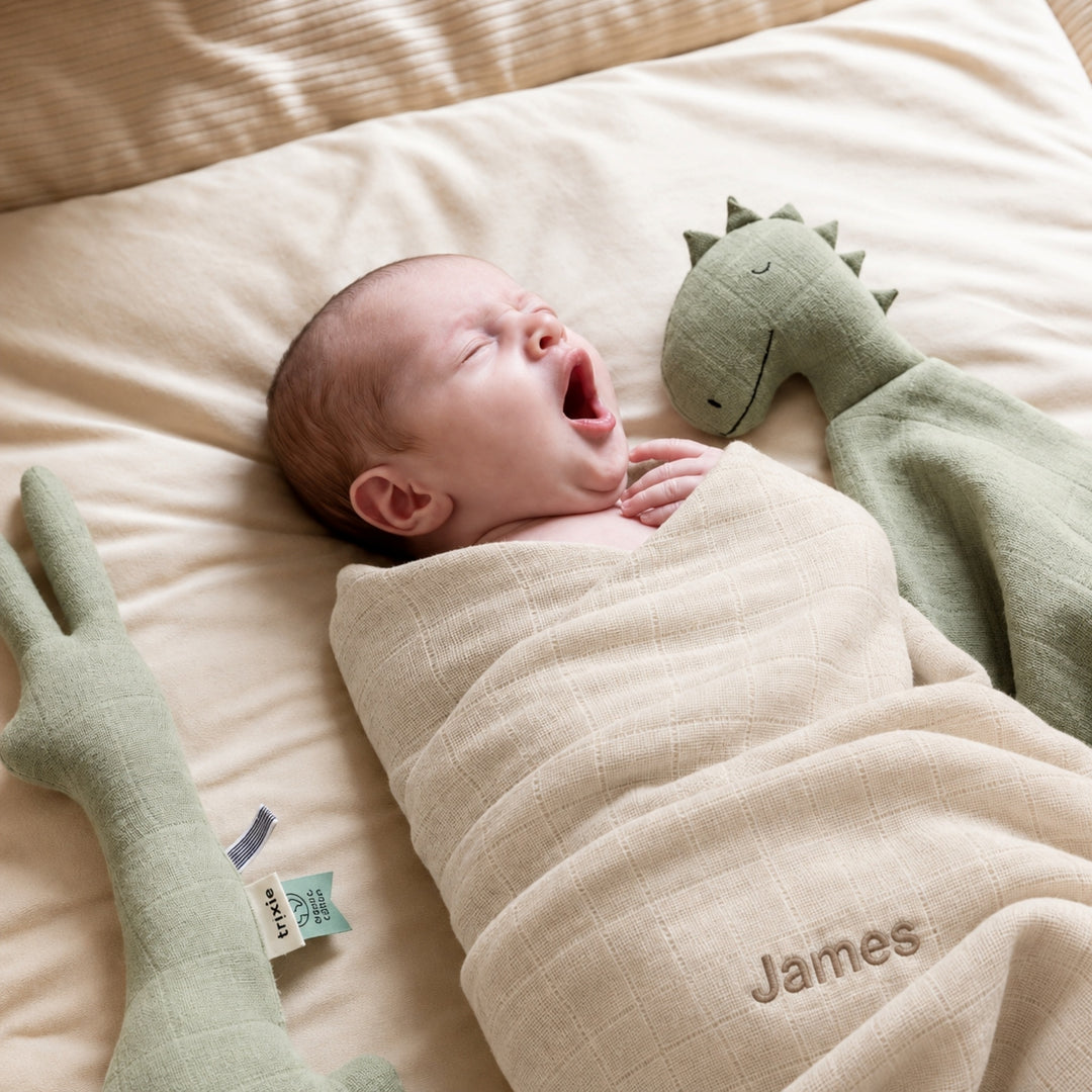 Newborn baby wrapped in beige Trixie muslin swaddle with personalised name James, UAE