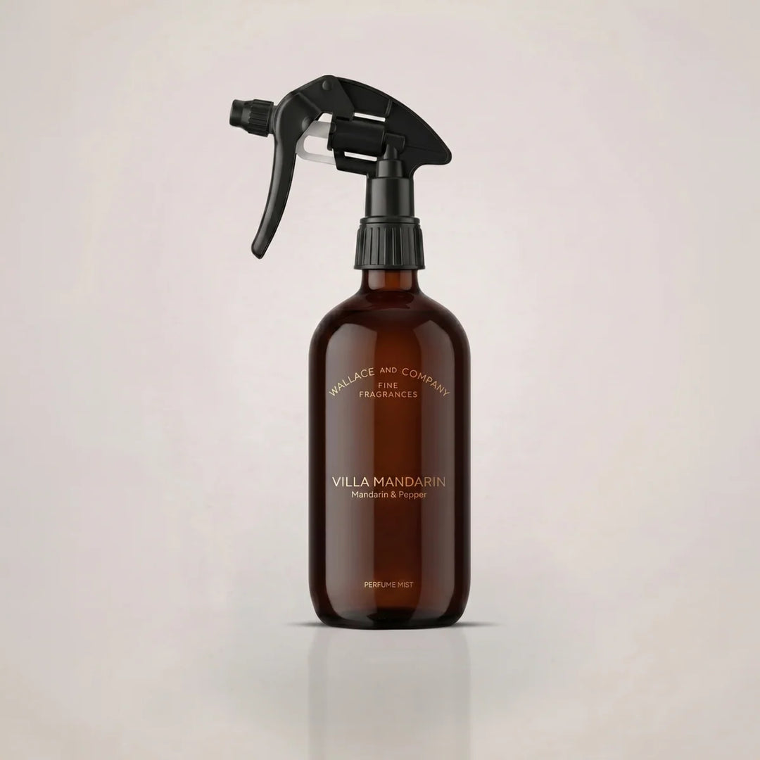An amber glass spray bottle with a black trigger sprayer, featuring gold text that reads 'VILLA MANDARIN' and 'Mandarin & Pepper'.