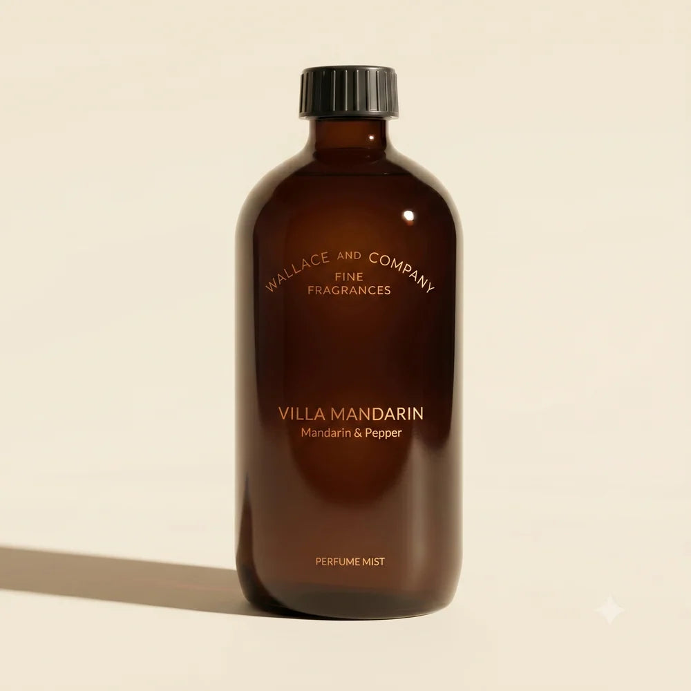 A dark amber glass bottle of Wallace and Company Villa Mandarin perfume mist, featuring a black cap and gold lettering, set against a warm beige background with a soft shadow.