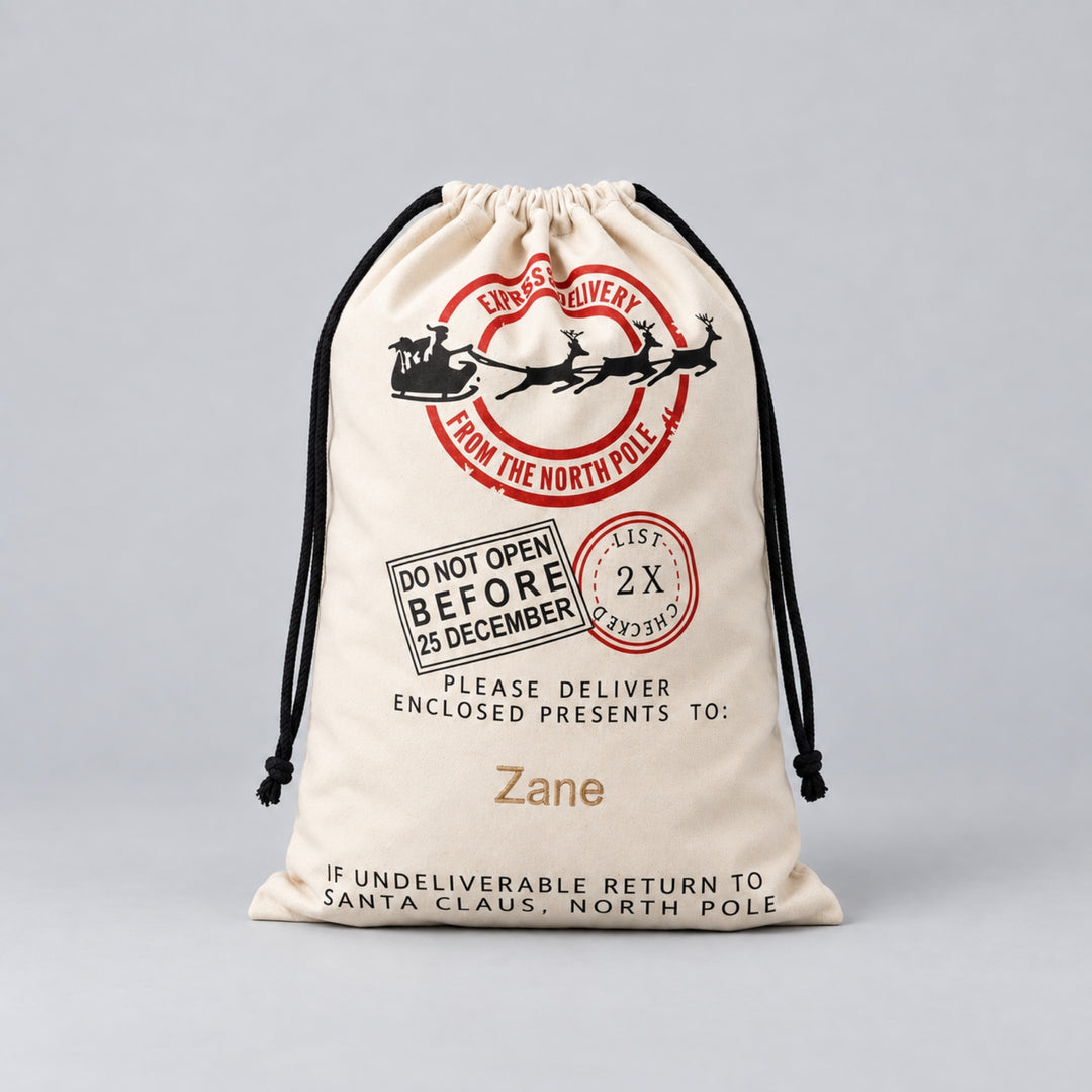 Personalised cream Christmas drawstring sack with Santa sleigh, reindeer and North Pole express delivery design, finished with the name “Zane”.